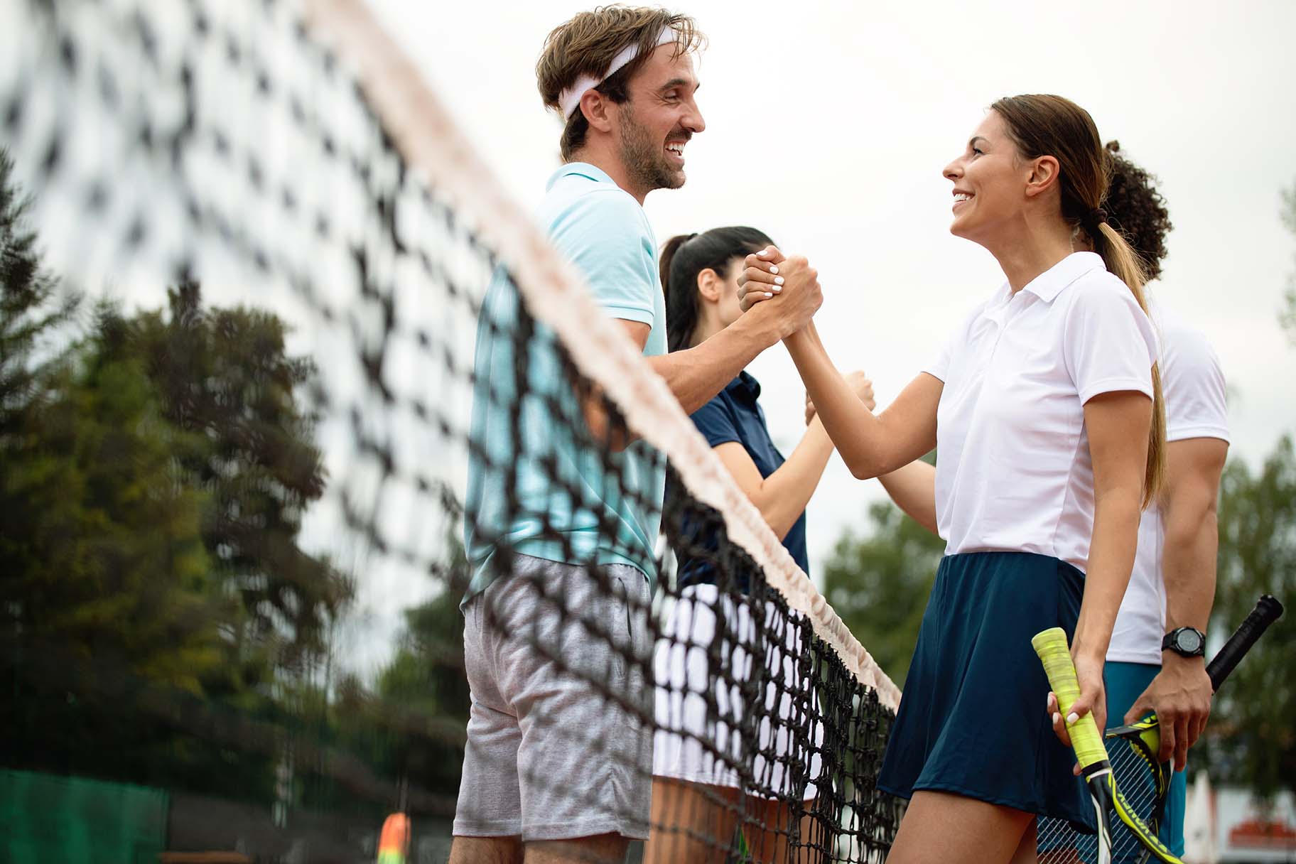 Happy fit people playing tennis together. Sport concept